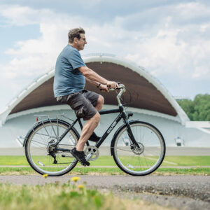 Older man riding Oolter Eke e-bike at Tallinn Song Festival Grounds on a summer day