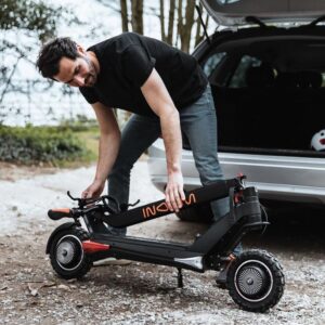 Man folding the Inokim OXO electric scooter to the car's trunk.